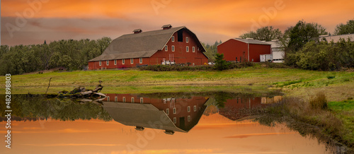 A red barn and a large reflection pond at sunrise on a farm in the Willamette Valley near Bellfountain Oregon photo