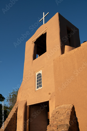 Adobe bell tower and white cross of San Miguel Chapel in Santa Fe, New Mexico photo