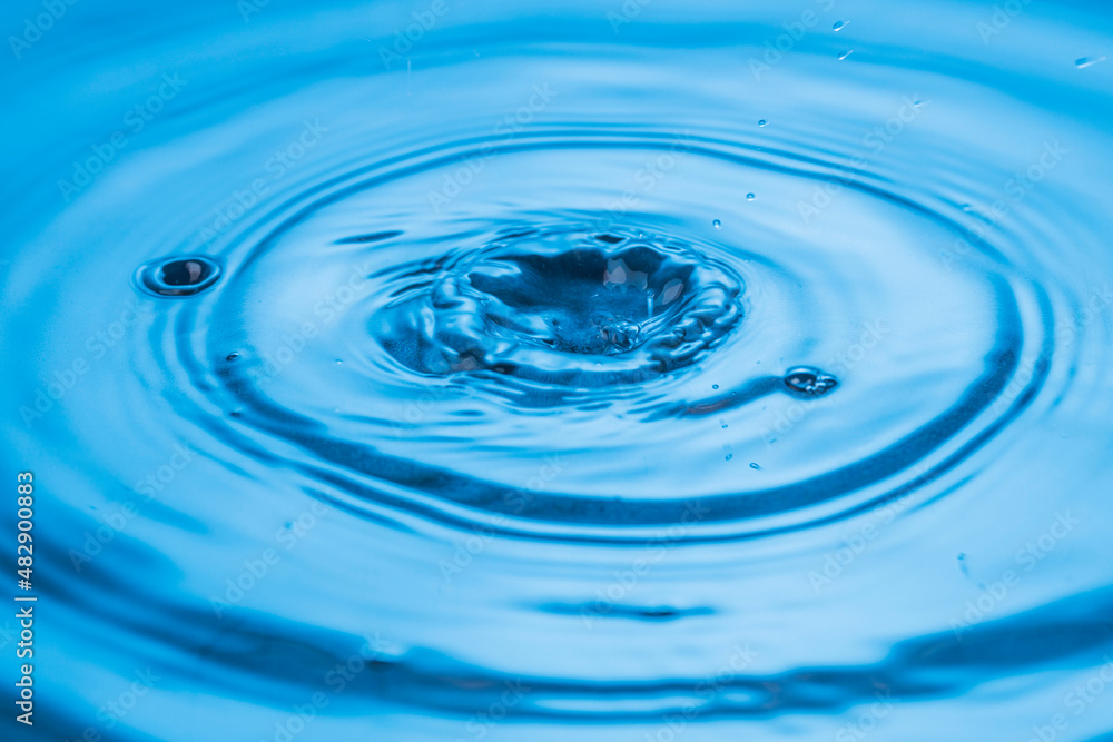 Beautiful view of drops making circles on blue water surface isolated on background. Beautiful view of drops making circles on blue water surface isolated on background.