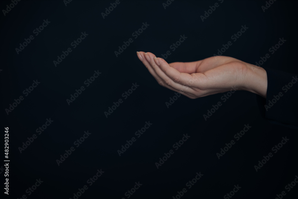 Open woman's hand, palm up isolated on black background. Mock up. Copy space. Template. Blank.