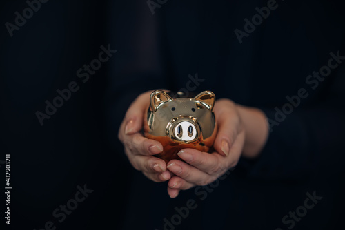 Female holding a golden piggy bank