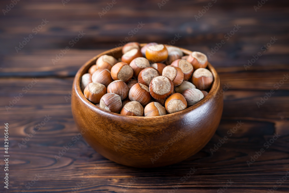 food, hazelnuts in a wooden bowl on a dark wooden background,selective focus food, hazelnuts in a wooden bowl on a dark wooden background,selective focus