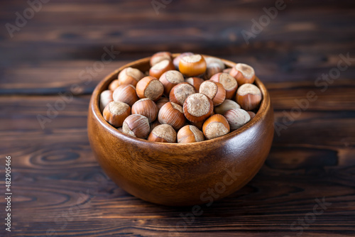food, hazelnuts in a wooden bowl on a dark wooden background,selective focus
