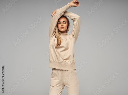 Sexy blonde woman wear of beige set of tracksuit photo