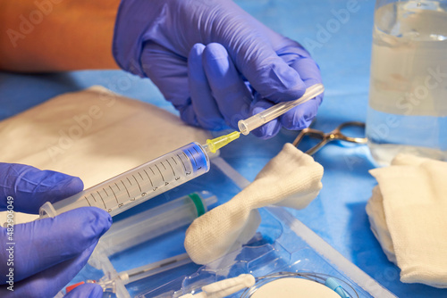 Medical syringe in the hands of a doctor. Doctor's hands in gloves close-up