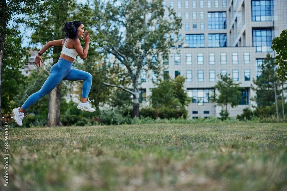 Young and athletic woman running through the park