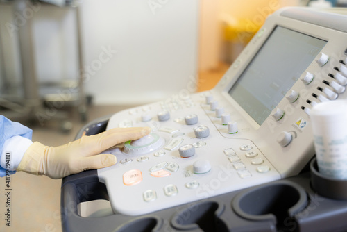 the doctor's hand on the ultrasound machine