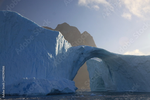 ogromna góra lodowa w kształcie łuku dryfująca u wybrzeży grenlandii