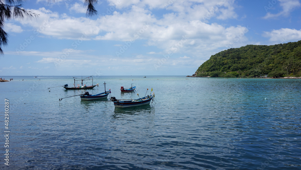 Boats on the sea and a small island on horizon Boats on the sea and a small island on horizon