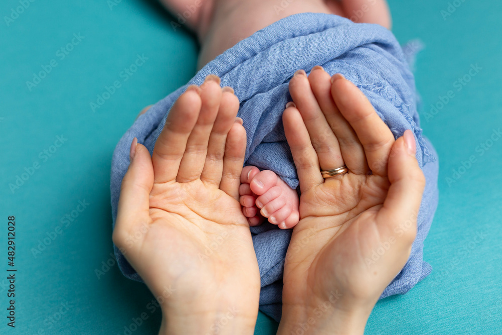 little feet of a newborn baby in mother's hands little feet of a newborn baby in mother's hands