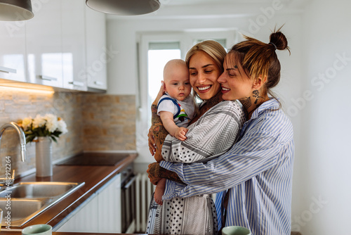 Two lesbian women with a baby boy at home photo