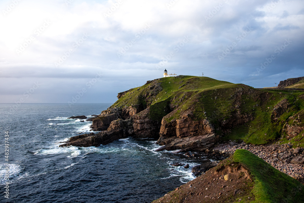 Stoer Lighthouse, Unapool, Scotland - Dramatic stone cliffs in the foreground. Stoer Lighthouse, Unapool, Scotland - Dramatic stone cliffs in the foreground.