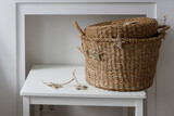 A wicker storage basket with a lid, a garland with stars on a white table near the fireplace. Scandinavian style. Minimalism
