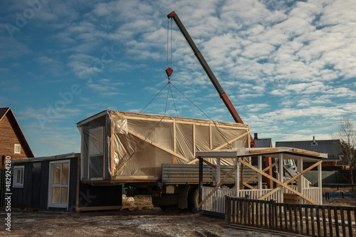 Delivery and installation of a modular frame house. Frame construction of small houses. Modular housing construction. Your house. An inexpensive house.