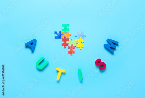 Fototapeta Naklejka Na Ścianę i Meble -  Word AUTISM with colorful puzzle pieces on color background