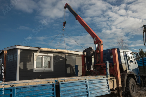 Delivery and installation of a modular frame house. Frame construction of small houses. Modular housing construction. Your house. An inexpensive house.
