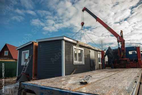 Delivery and installation of a modular frame house. Frame construction of small houses. Modular housing construction. Your house. An inexpensive house.