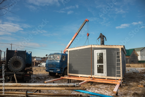 Delivery and installation of a modular frame house. Frame construction of small houses. Modular housing construction. Your house. An inexpensive house.
