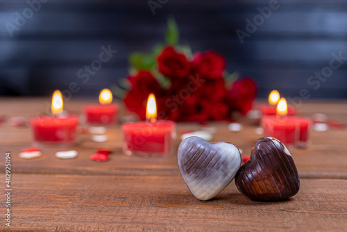Valentines Day concept chocolate candies and red roses with candles