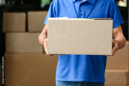 Male courier of delivery company near automobile with parcels
