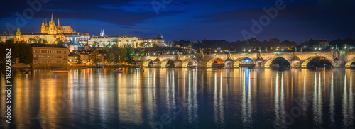 Astonishing panoramic  view from a distance of the Prague Castle at night  showing the bridge s reflection.