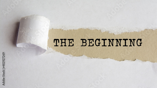 THE BEGINNING. words. text on grey paper on torn paper background