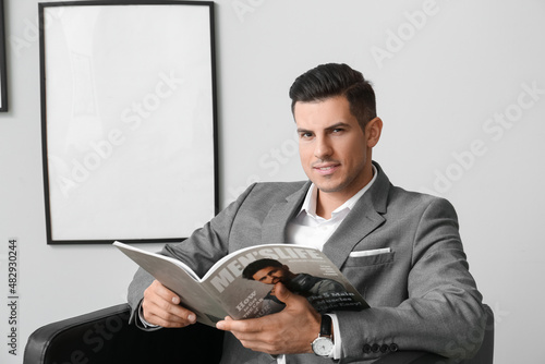 Fashionable man with magazi...