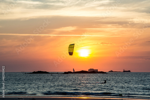 Kitesurfing against sunset at shores of Brittany, France