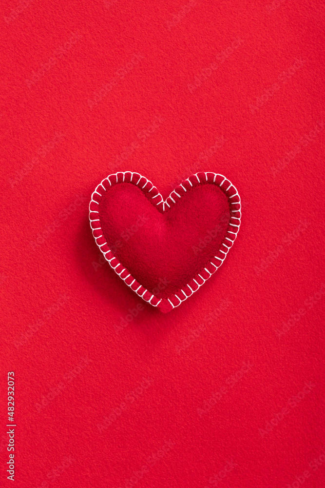 Soft handmade felt heart on red felt background