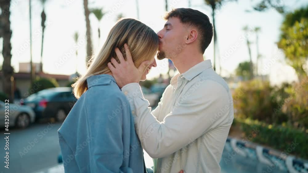 Young couple kissing and hugging each other standing at street Young couple kissing and hugging each other standing at street