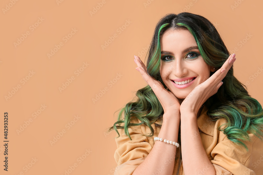 Beautiful young woman with unusual green hair on color background