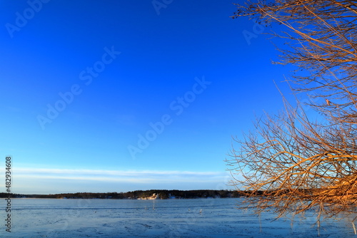 Sea landscape during the winter. Snow and ice covering the lake. With a horizon. Blue sky and nice weather. One calm day. Stockholm, Sweden.