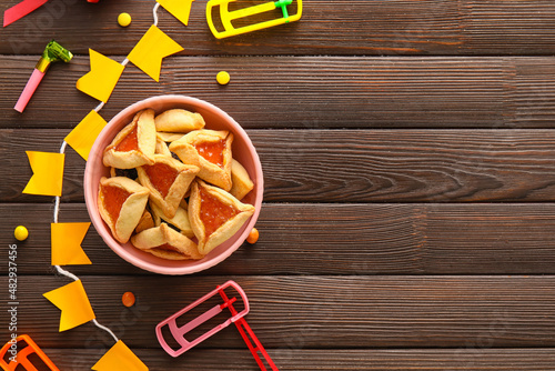 Hamantaschen cookies and rattles for Purim holiday on wooden background