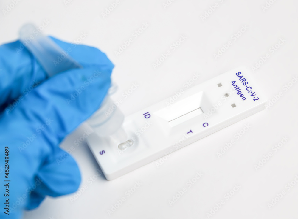 Man makes a covid-19 antigen pcr test macro. The test showed a positive result. Man makes a covid-19 antigen pcr test macro. The test showed a positive result.