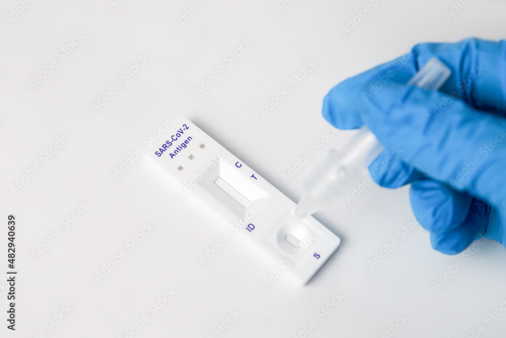 Man makes a covid-19 antigen pcr test macro. The test showed a positive result.