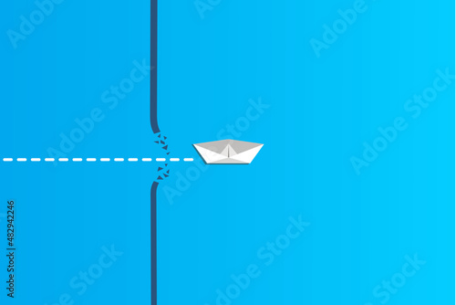 Concept of overcoming barriers on the way to goal with white paper ship breaking through obstacle on blue background. Deal with difficulties on the way to target.