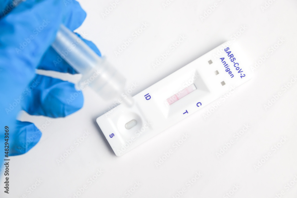 Man makes a covid-19 antigen pcr test macro. The test showed a positive result