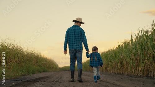 Foto Happy family, child father walk together hand in hand on plantation in autumn