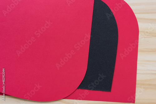 red paper background with black design element on wood