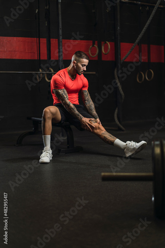 Obraz na płótnie Chico musculoso con camiseta roja practicando deporte en un gym w salonie