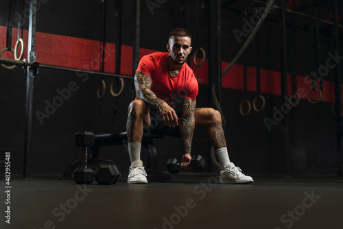 Chico musculoso con camiseta roja practicando deporte en un gym