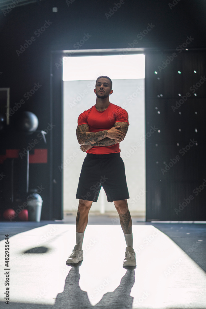 Chico musculoso con camiseta roja practicando deporte en un gym