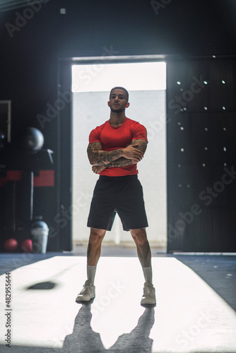 Obraz na płótnie Chico musculoso con camiseta roja practicando deporte en un gym w salonie