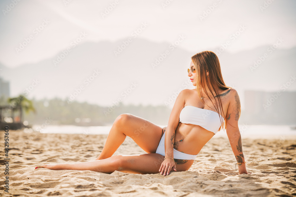 woman modeling a white bikini on the beach woman modeling a white bikini on the beach