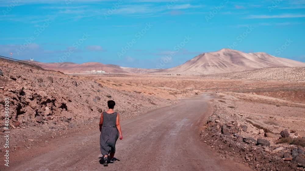 Woman walks in a deserted street holding our his arms. Freedom concept Woman walks in a deserted street holding our his arms. Freedom concept