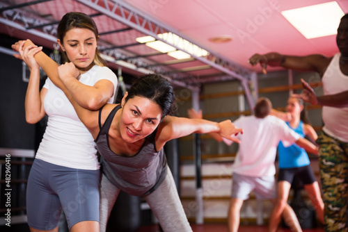 Two woman is training on the self defense course in gym