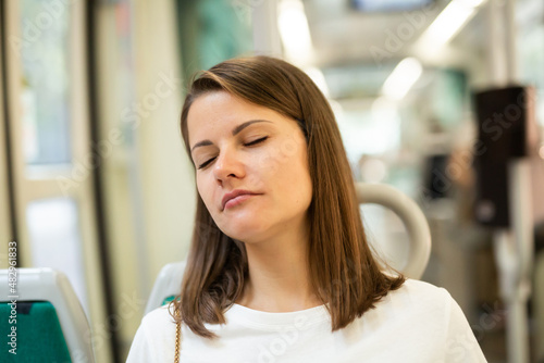 Free Download Portrait of young woman going to work by bus or trolley at early morning sitting with closed eyes - GFXLoad