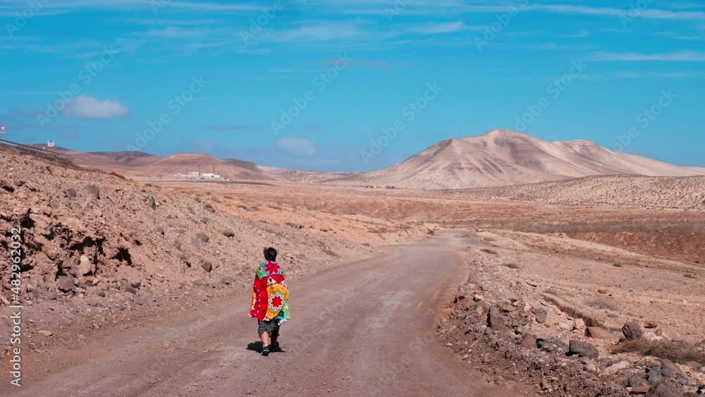 woman walks on the path of freedom. Girl walks in the dunes of Fuerteventura near the Sotavento beach woman walks on the path of freedom. Girl walks in the dunes of Fuerteventura near the Sotavento beach