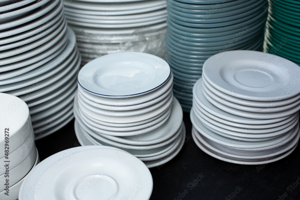 A view of several stacks of restaurant plates and saucers. A view of several stacks of restaurant plates and saucers.