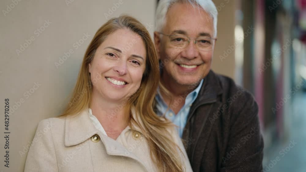 Middle age couple couple smiling confident hugging each other at street Middle age couple couple smiling confident hugging each other at street